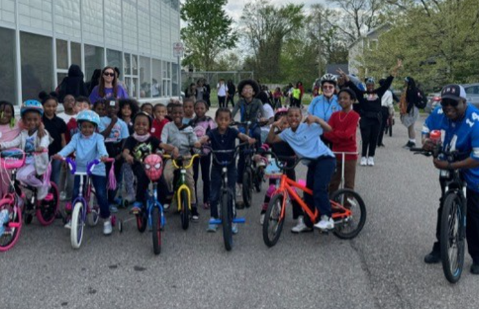  Students and staff standing in front of school with their bike 